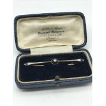 A Victorian gold bar brooch set with a single pearl. Weighs 2.64grams. Comes with a Miller & Muir
