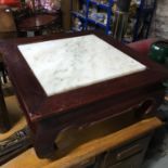 An oriental style table with marble insert. Measures 33x70x70cm