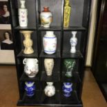 A Small shelving display showing a collection of Chinese miniature vases.