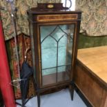 An Edwardian inlaid glass display cabinet, fitted with glass shelves, complete with key (