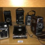 A Lot of vintage cameras which includes Bell & Howell cine camera, Kodak bellow cameras and