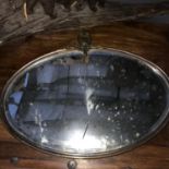 An Art Deco Bronzed metal framed oval mirror with bevel edge. Measures 46x58cm