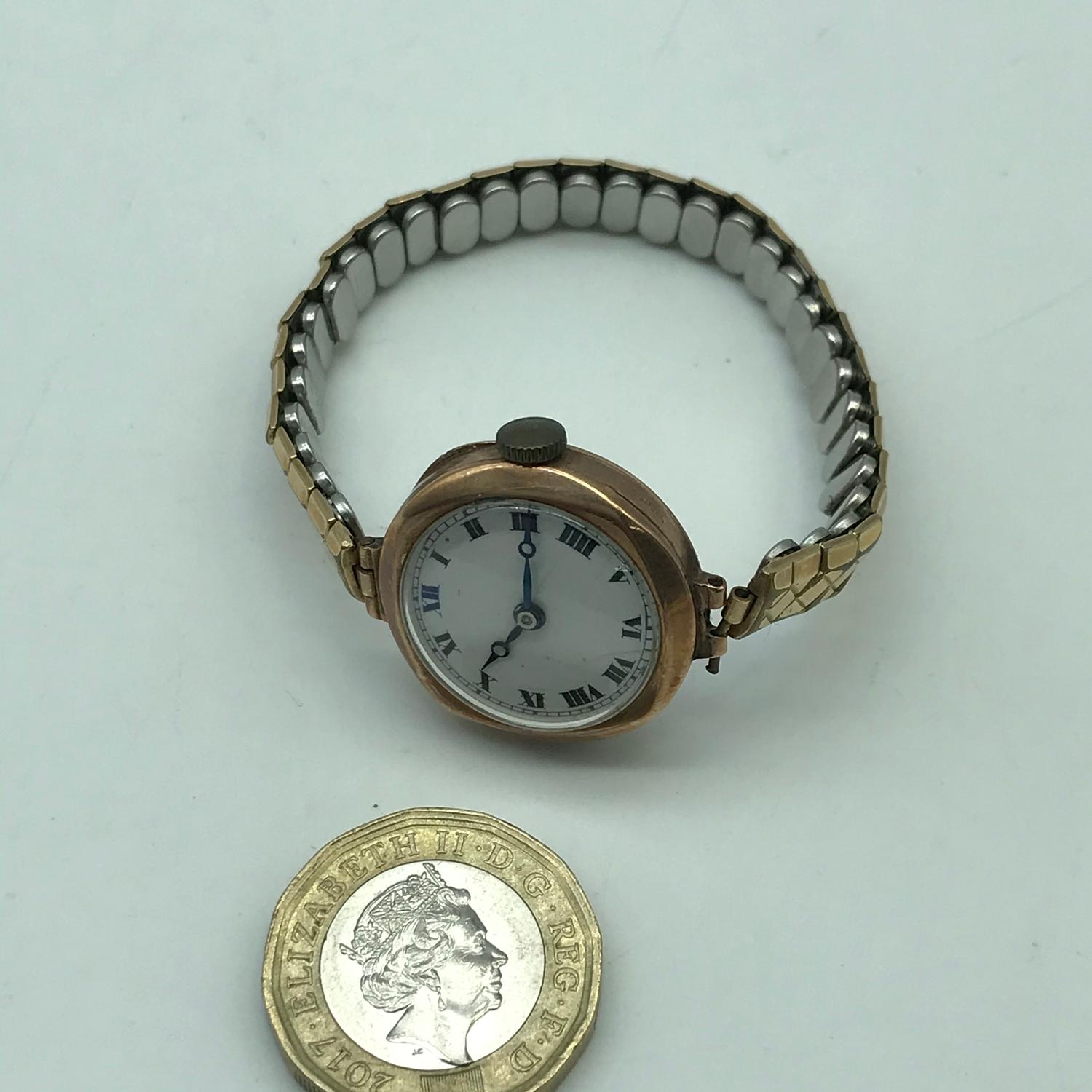 A 9ct gold ladies cased watch with plated bracelet. In a working condition
