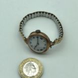 A 9ct gold ladies cased watch with plated bracelet. In a working condition