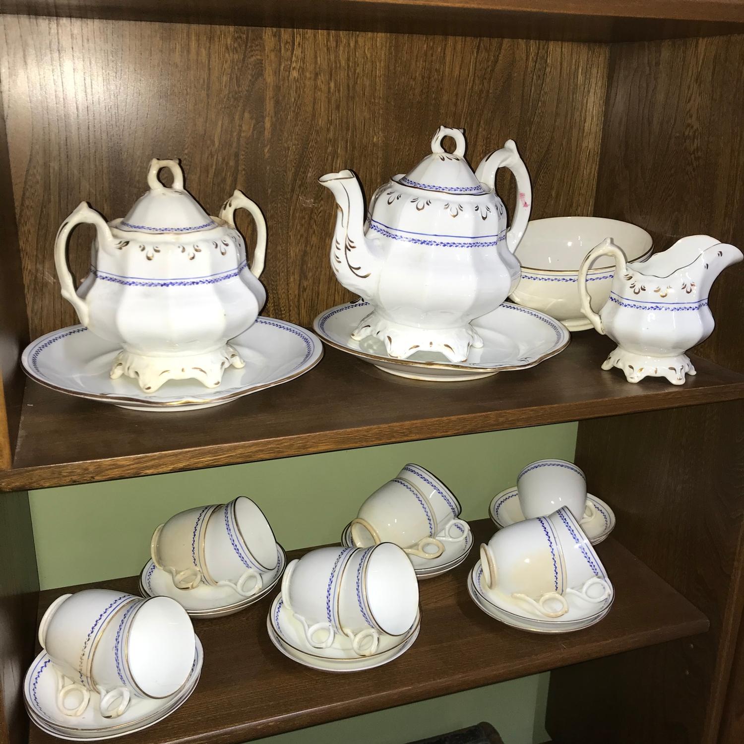 A Victorian porcelain tea set which includes tea pot, sugar and cream. Includes 11 cups and 12