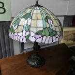 A Large Tiffany style table lamp, Designed with a bronzed metal base. In a working condition.