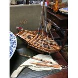 A Hand made war boat model, showing canons, canon balls & rigging. On a stand. Measures H 43 cm L