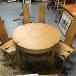 A retro Scandinavian style light wood table, complete with four uniquely designed chairs