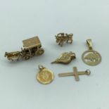 A Lot of six 9ct gold charms and pendants to include horse with cart, bellows, bull, cross and two