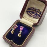 A Pair of 10ct gold earrings set with a pink tear drop stone [Total weight, 1.1grams].