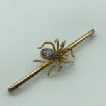 Antique 9ct gold spider bar brooch, detailed with a large amethyst gem stone and an emerald