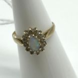 A Ladies 9ct gold ring set with a single opal stone surrounded by clear glass stones. Ring size K