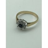 9ct gold ladies ring set with black centre stone surrounded by clear cut stones [1.85g]