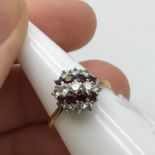A Beautiful example of a ladies Diamond and Ruby cluster ring. Possibly Set with a high gold and