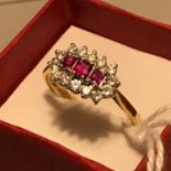 An Antique Birmingham 18ct gold ladies ring set with three square cut Rubies surrounded by diamonds.