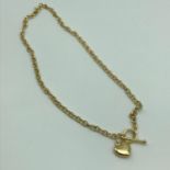 A Ladies 9ct gold necklace, designed with a t-bar and heart pendant. Weighs 4.3grams