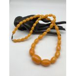 A Vintage Amber graduating bead necklace made from egg yoke/ Butter scotch Amber. [Weighs 61.6grams]
