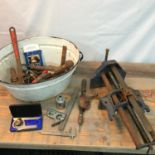 An old enamelled two handle wash basin containing a quantity of old tools to include Measuring