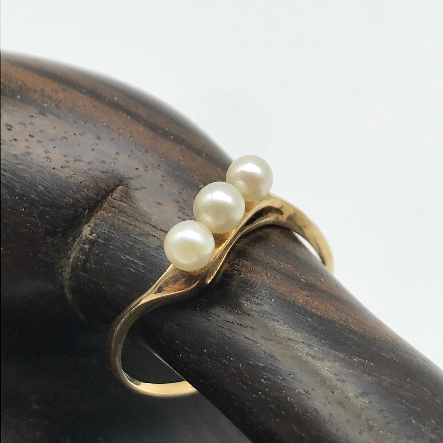 A Ladies 9ct gold twist ring set with three pearls. Ring size P and weighs 1.50grams.