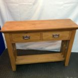 A Contemporary solid light oak console table designed with two drawers and under shelf. Measures