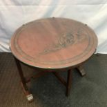 A vintage hand carved oriental flip top table set with a glass top. Carving shows figures, junk boat