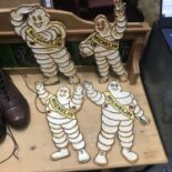 A Collection of four cast metal Michelin man advertising signs. [32cm in height]