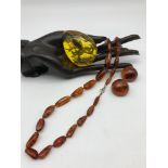 A Vintage Bakelite amber necklace with sterling silver clasp, Amber clip on earrings and Bakelite
