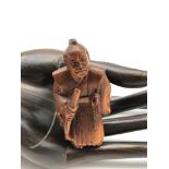 A Japanese hand carved netsuke figure of a samurai with sword and fan. Not signed.
