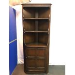 A vintage Ercol corner unit. Three tier shelving to the interior. Single storage bottom with