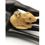 A Japanese hand carved Tagua nut netsuke figure of a Rat carrying a baby rat on its back. Both