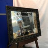 Antique Guinness Dublin advertising mirror designed with hand carved dark wood frame. [Measure