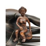 A Japanese hand carved netsuke figure of a nude geisha sat on a rock. Signed tot he base by the