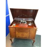 Antique Tyrela Gramophone within a mahogany case. Comes with a pile of old records. In a working