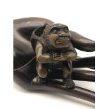A Japanese hand carved netsuke figure of an Oni Monster carrying a Hannya devil mask. Signed to