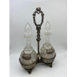 A Pair of Victorian facet cut crystal decanters within a fitted plated basket holder, Comes with