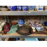 A Shelf of collectable oriental porcelain items which includes heavy resin sitting god figure,