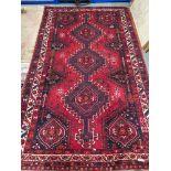 A Red Ground ornate hand woven rug.