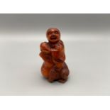 A Japanese hand carved netsuke of an elderly chap riding on top of a toad. Toad is detailed with