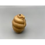 Japanese hand carved tagua nut netsuke of a snake designed with black bead eyes. [4cm]