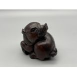 Japanese hand carved netsuke of a boar designed with black bead eyes and signed by the artist. [4cm]