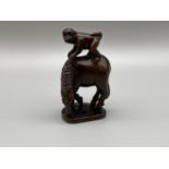 Japanese hand carved netsuke of a monkey sitting on top of a horse. Both designed with black bead