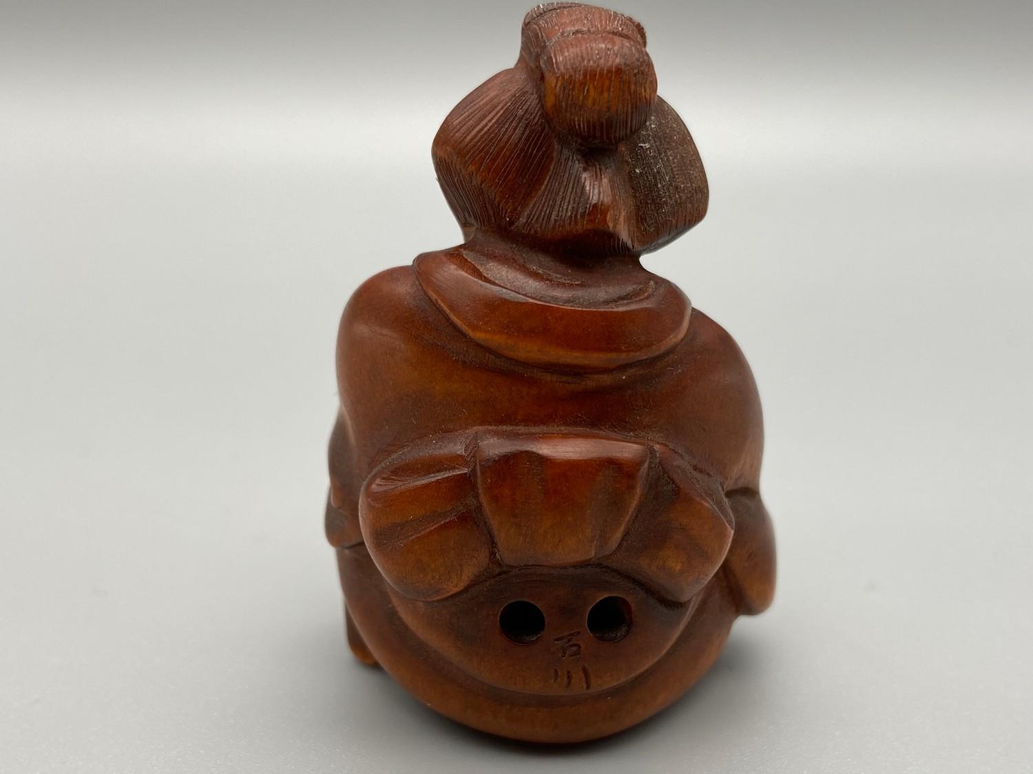 A Japanese hand carved netsuke of an elderly Geisha washing her feet. Signed by the artist. - Image 2 of 2