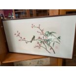 A Japanese silk tapestry of a bird perched on a cherry blossum branch. Signed by the artist.