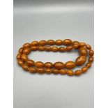 A Set of vintage egg yolk amber graduating beads, Weighs 68grams.