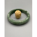 A Chinese green jade bangle [8cm diameter] together with a hand carved Thai Buddha head.