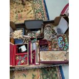 A Box containing a quantity of vintage costume jewellery which includes pearls, brooches and bangles