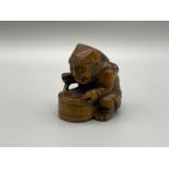 A Japanese hand carved netsuke of a Oni Monster stirring his potion.