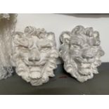 A Pair of large stone lion head sculptures.