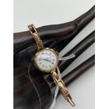 An Antique Ladies 9ct gold cased and band watch. 15 Jewels workings. [Weighs 6.19 grams without