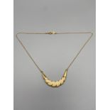 An 18ct gold chain set with a bone curved pendant attached.